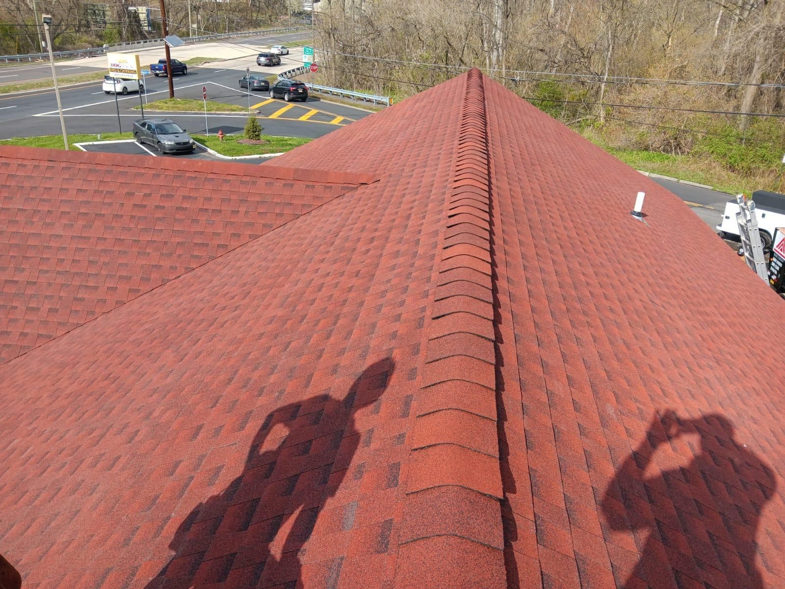 A Red Roof With a Shadow of a Person on It — Burlington, NJ — AD Roofer Siding & Gutters