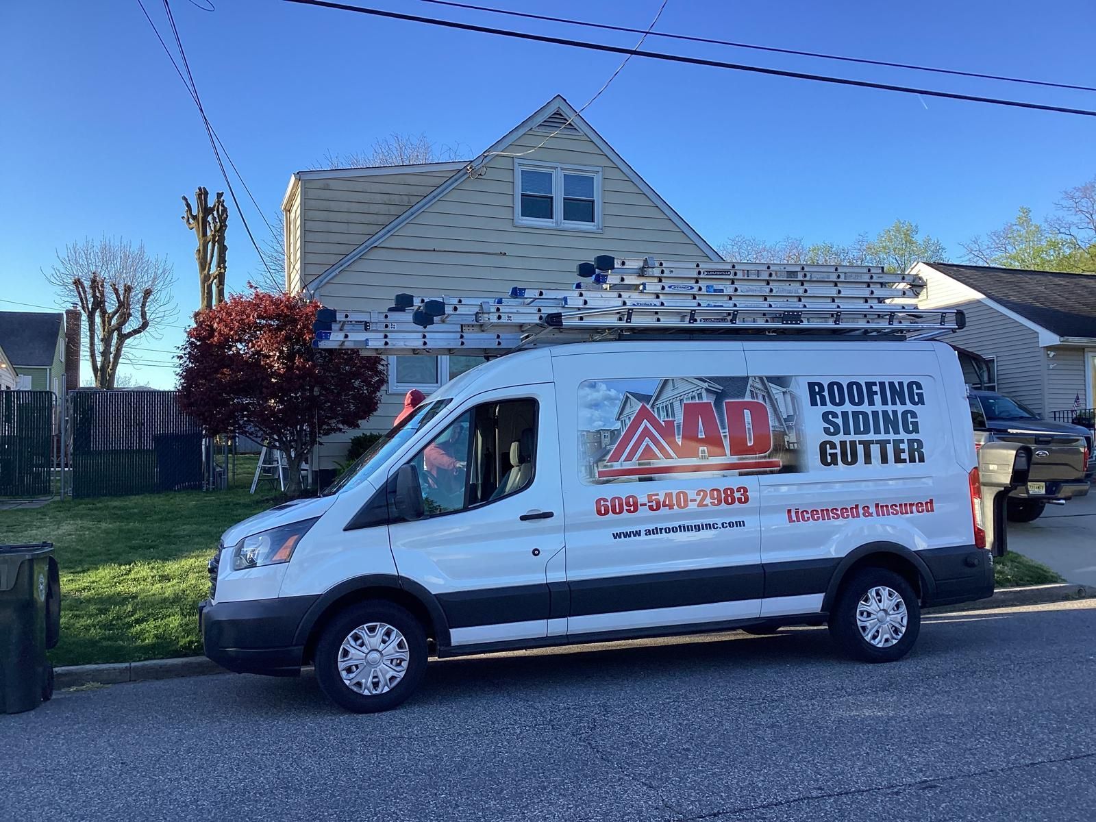 A White Van Is Parked in Front of a House — Burlington, NJ — AD Roofer Siding & Gutters
