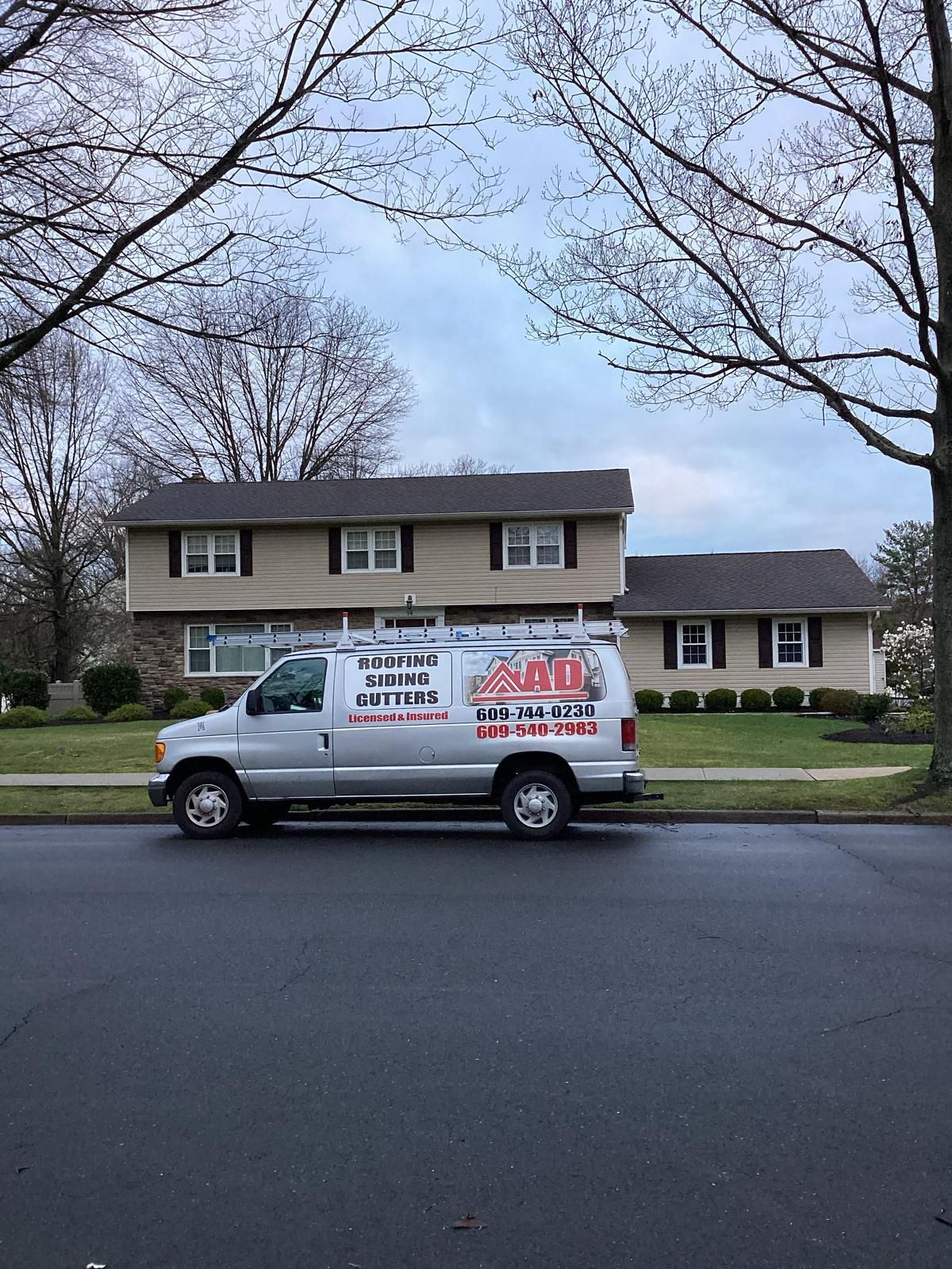 A White Van Is Parked in Front of a House — Burlington, NJ — AD Roofer Siding & Gutters