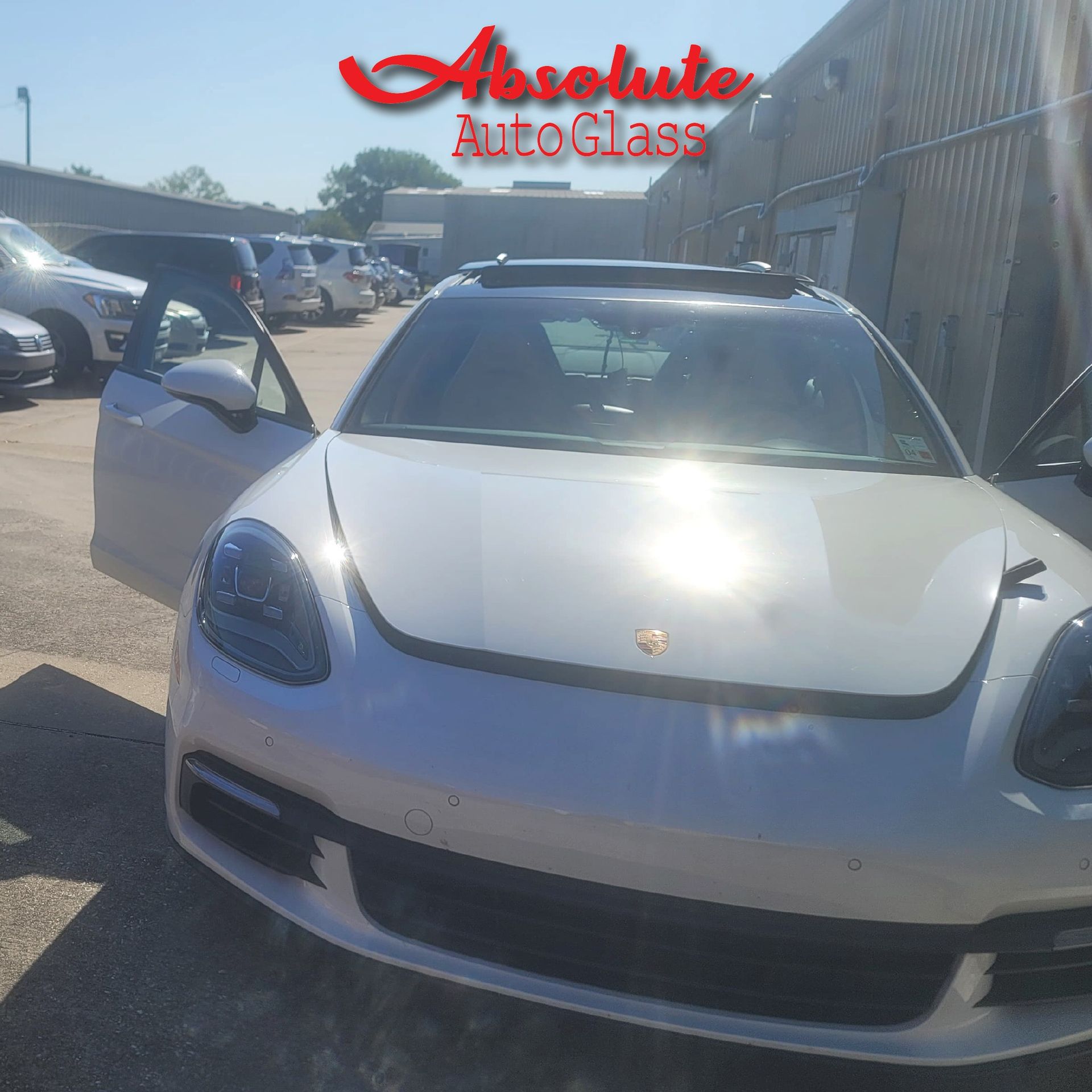 Dark grey Ford van with open doors parked on grass, in a wooded area.