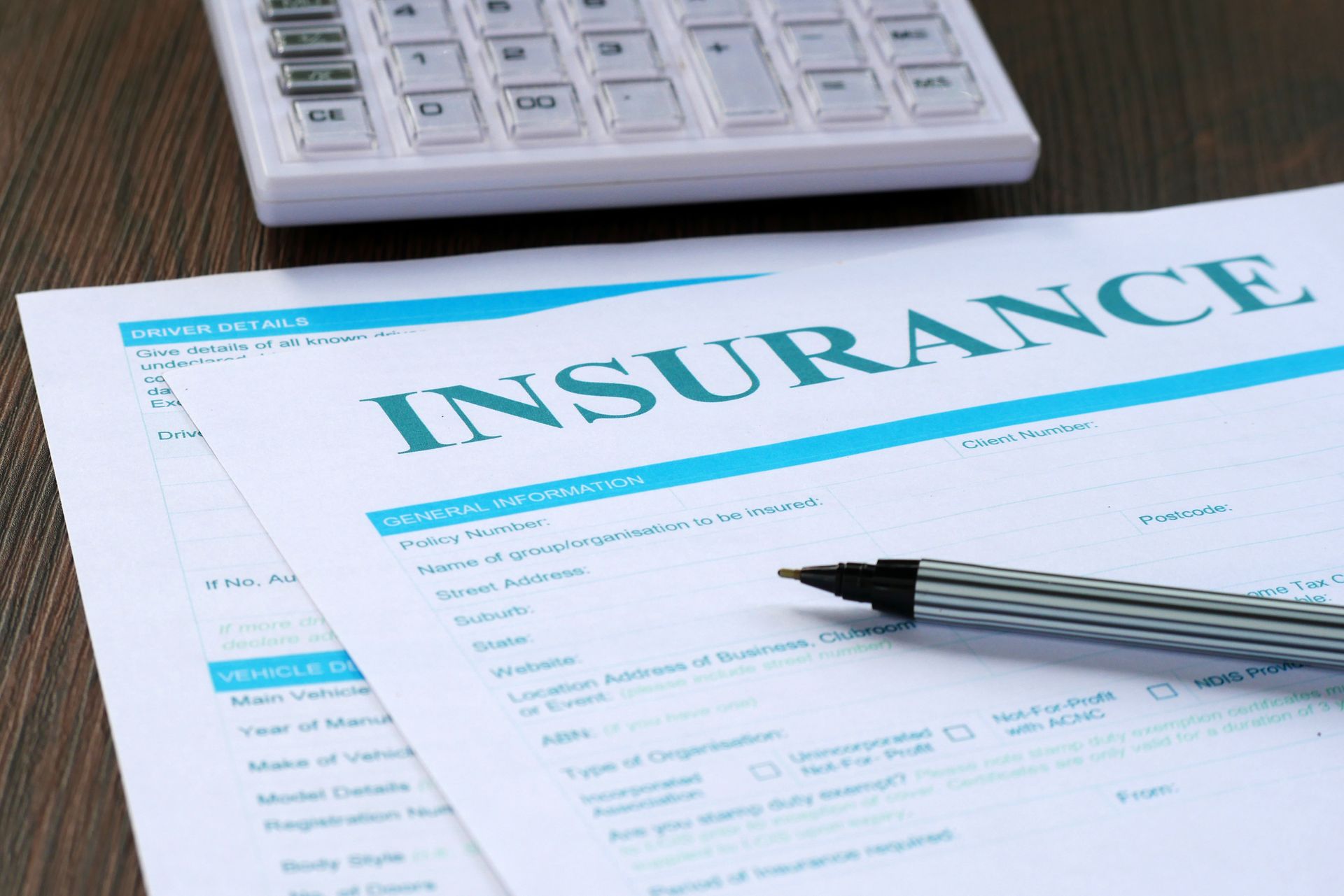 Insurance form, calculator and pen on the table