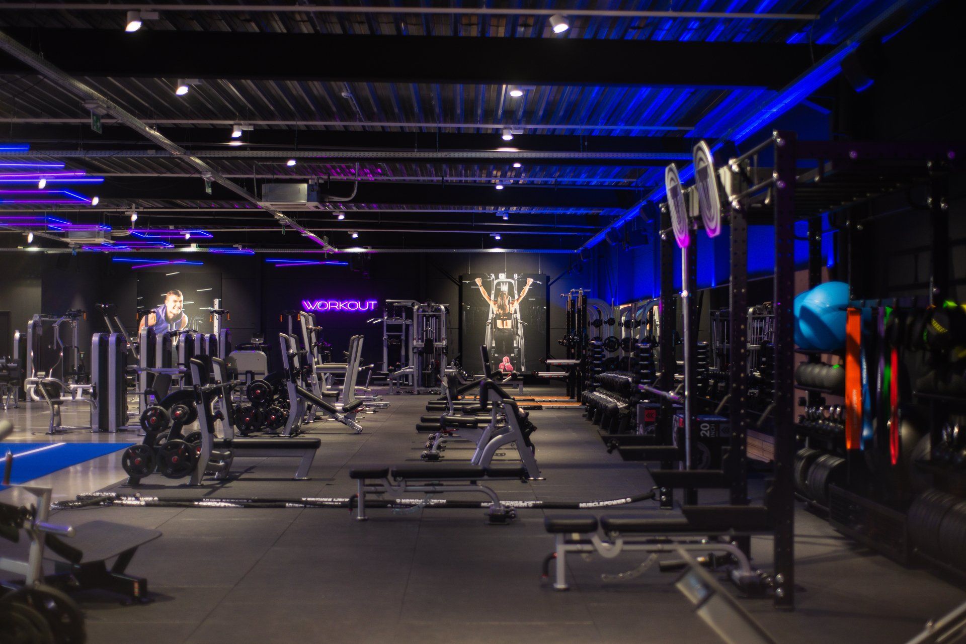 Een grote lege sportschool met veel fitnessapparatuur.