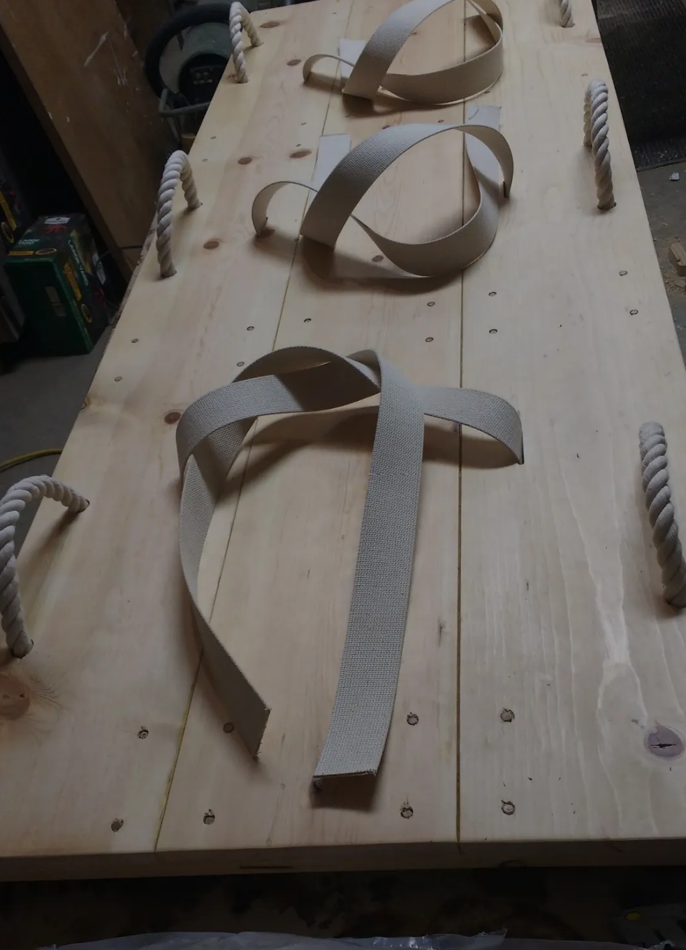 A wooden table with rope handles and ribbons on it