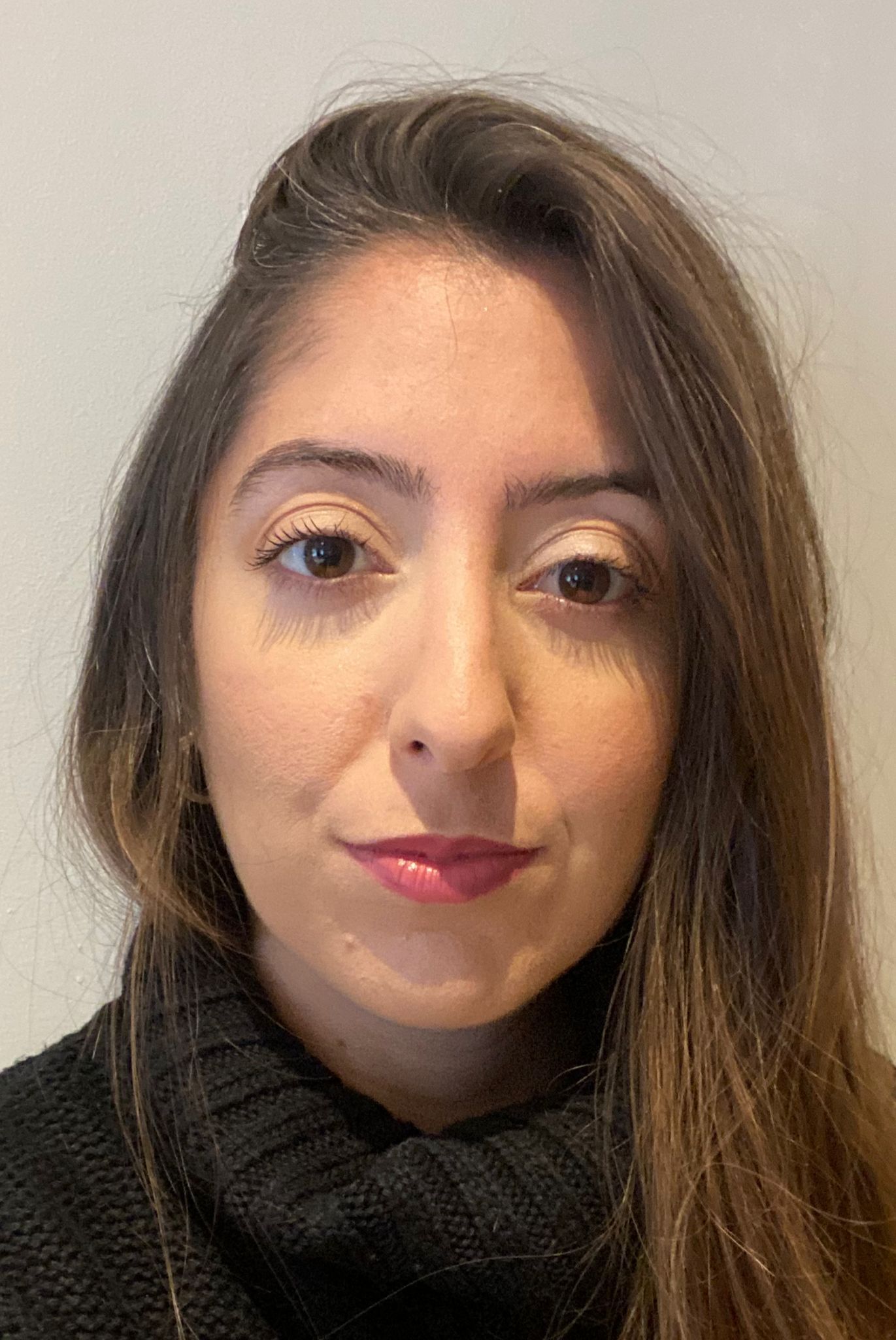 A close up of a woman 's face wearing a black sweater.
