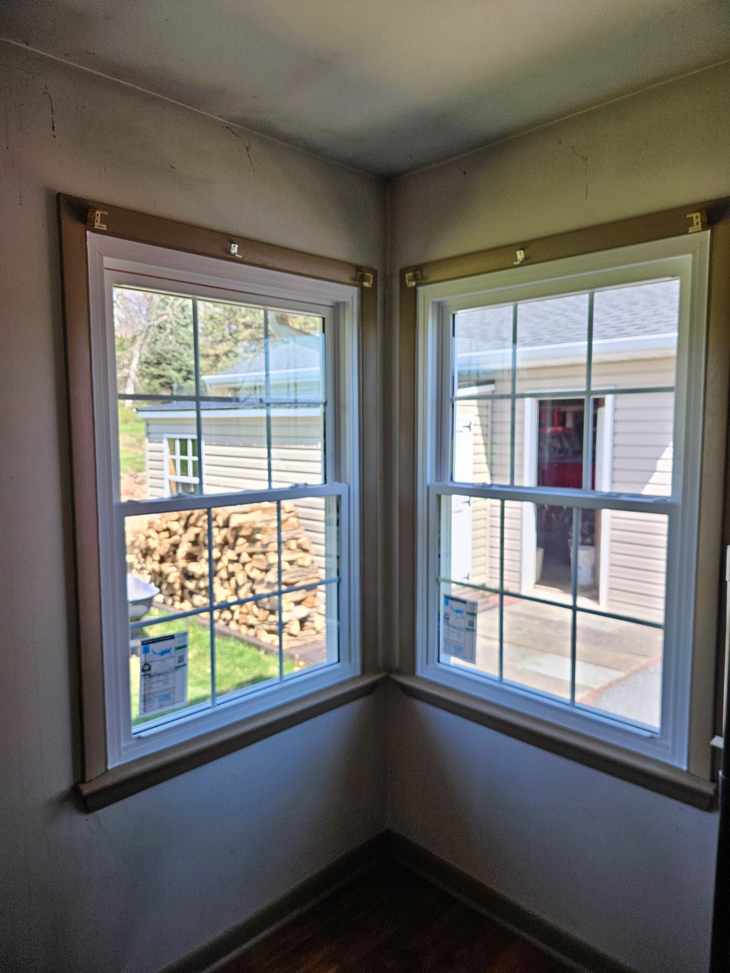 Corner room with two white-framed windows overlooking a residential courtyard and stairway