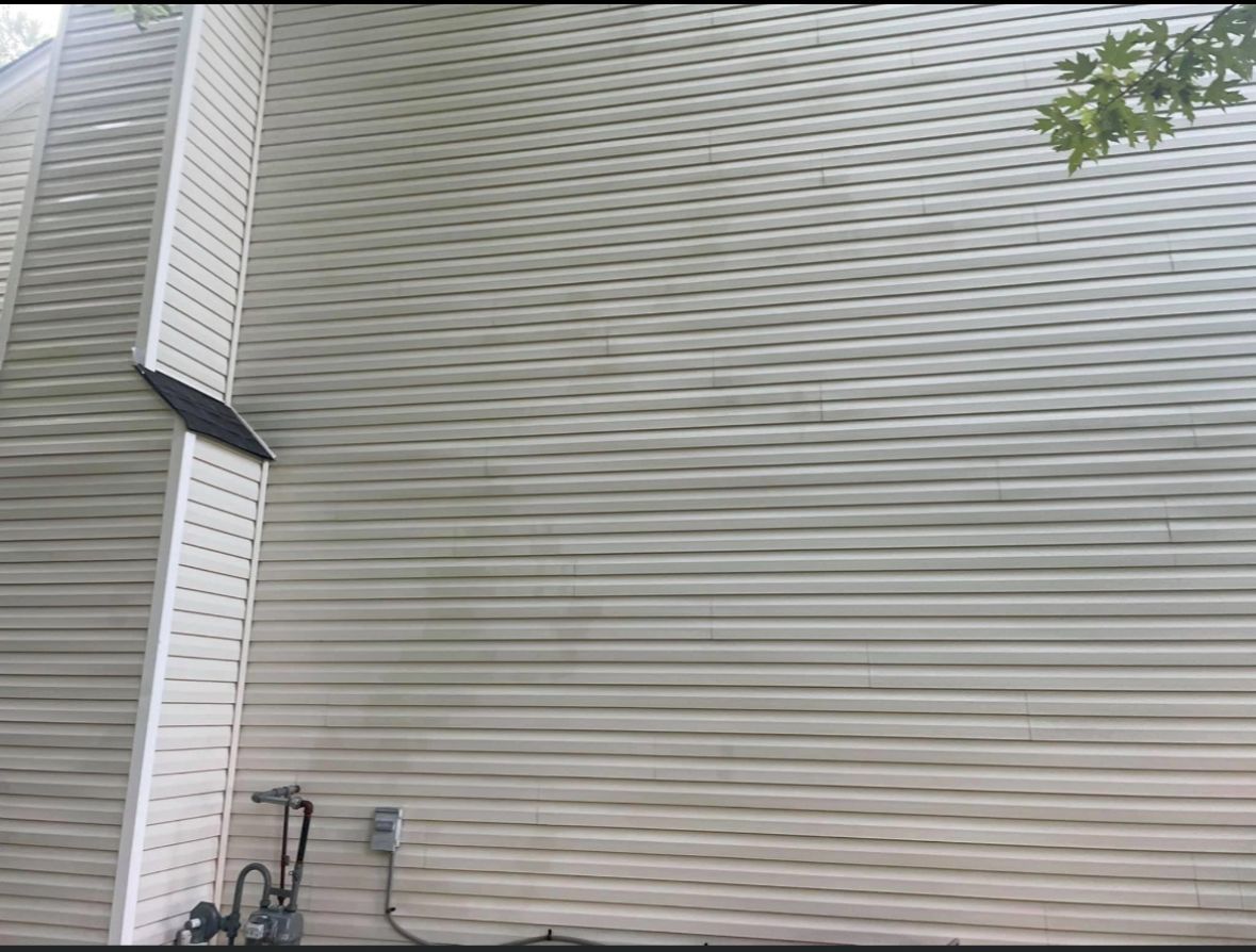 Beige vinyl siding on a building with a white column and gas meter.
