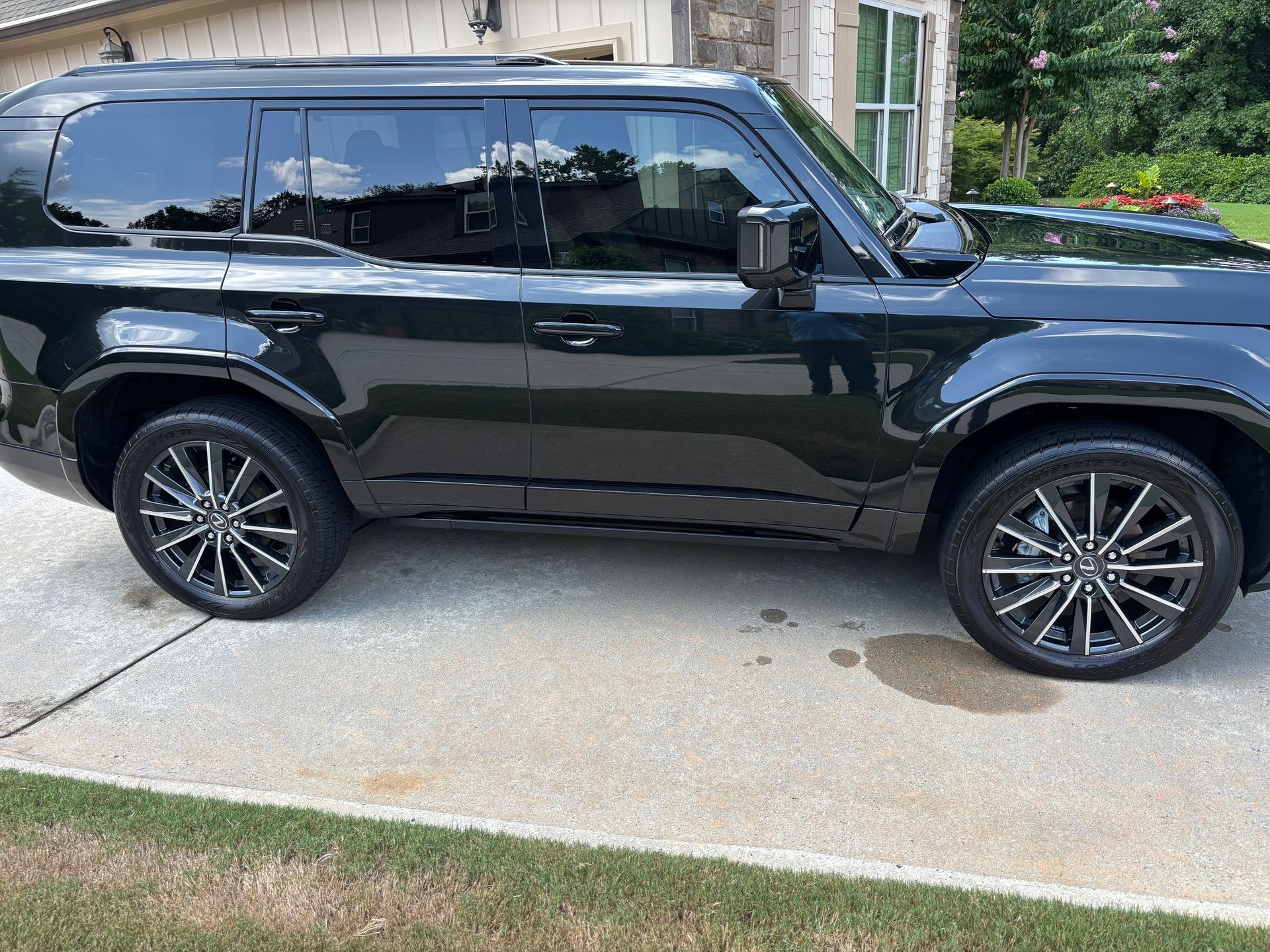 Black Land Rover Defender SUV parked on a concrete driveway.