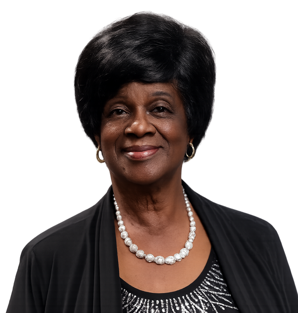 Woman with black hair, wearing a black top and pearl necklace, smiling.