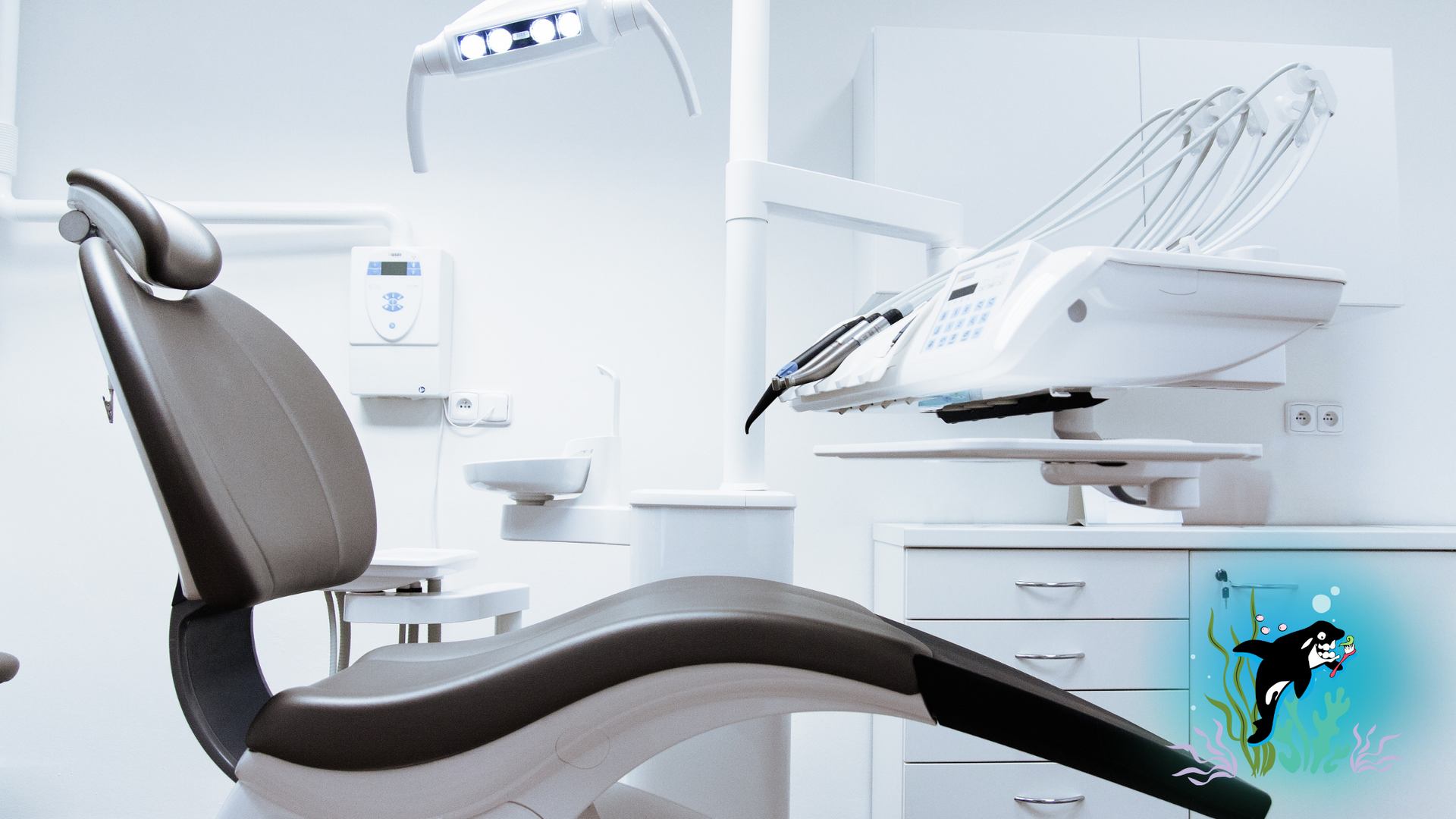 Dental chair in a bright, modern dentist's office with dental tools and equipment nearby.