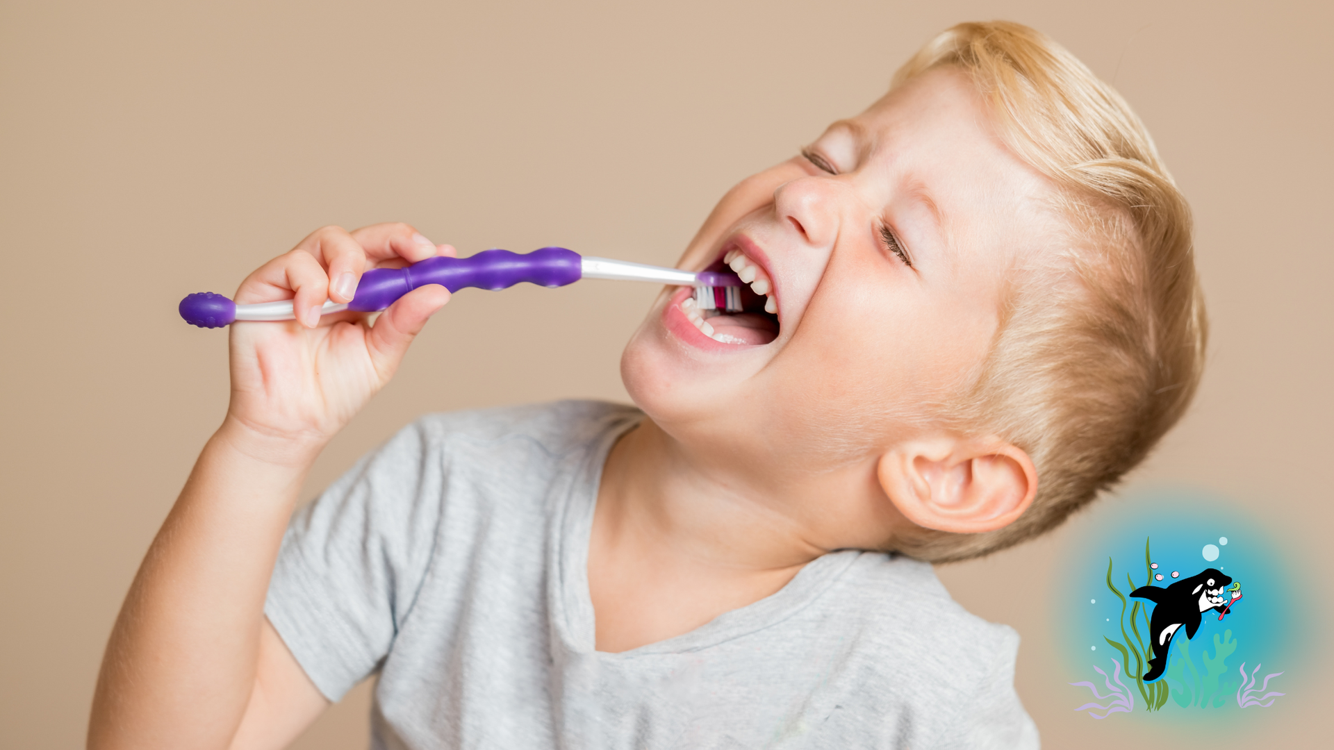 Boy brushing teeth with purple toothbrush, smiling.
