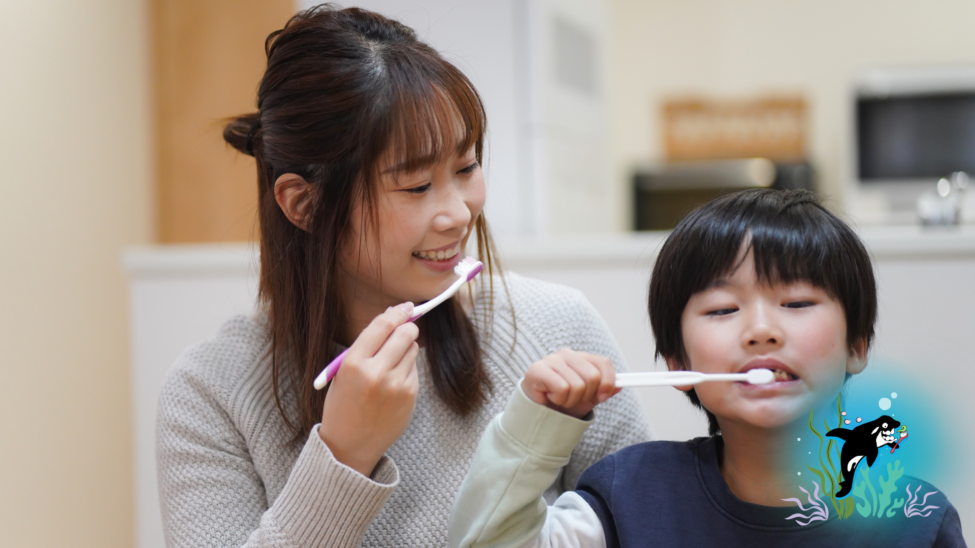 Woman and child brushing teeth together in a kitchen.