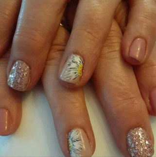 A close up of a person 's nails with a daisy design on them.