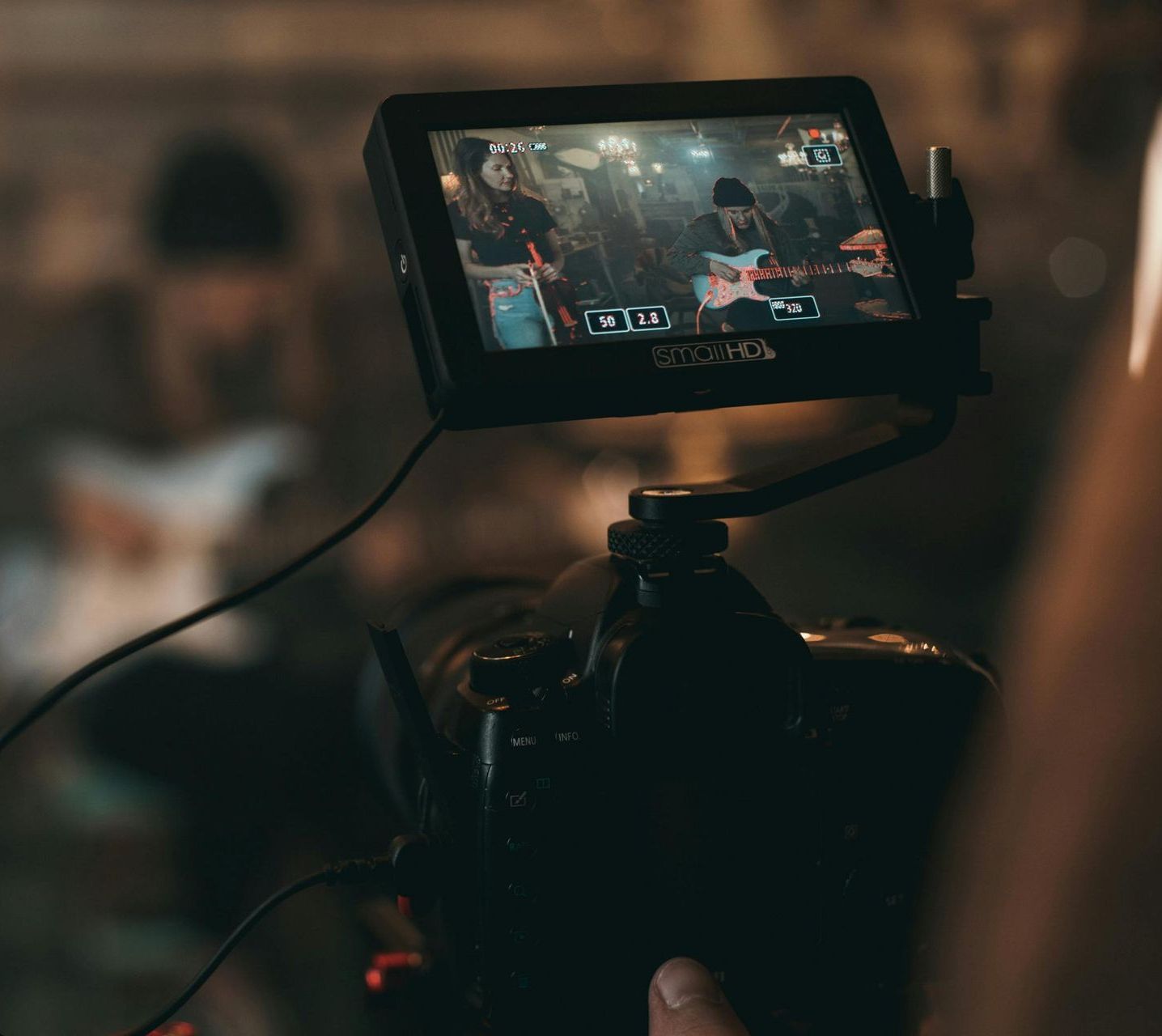 A person is holding a camera with a monitor attached to it.