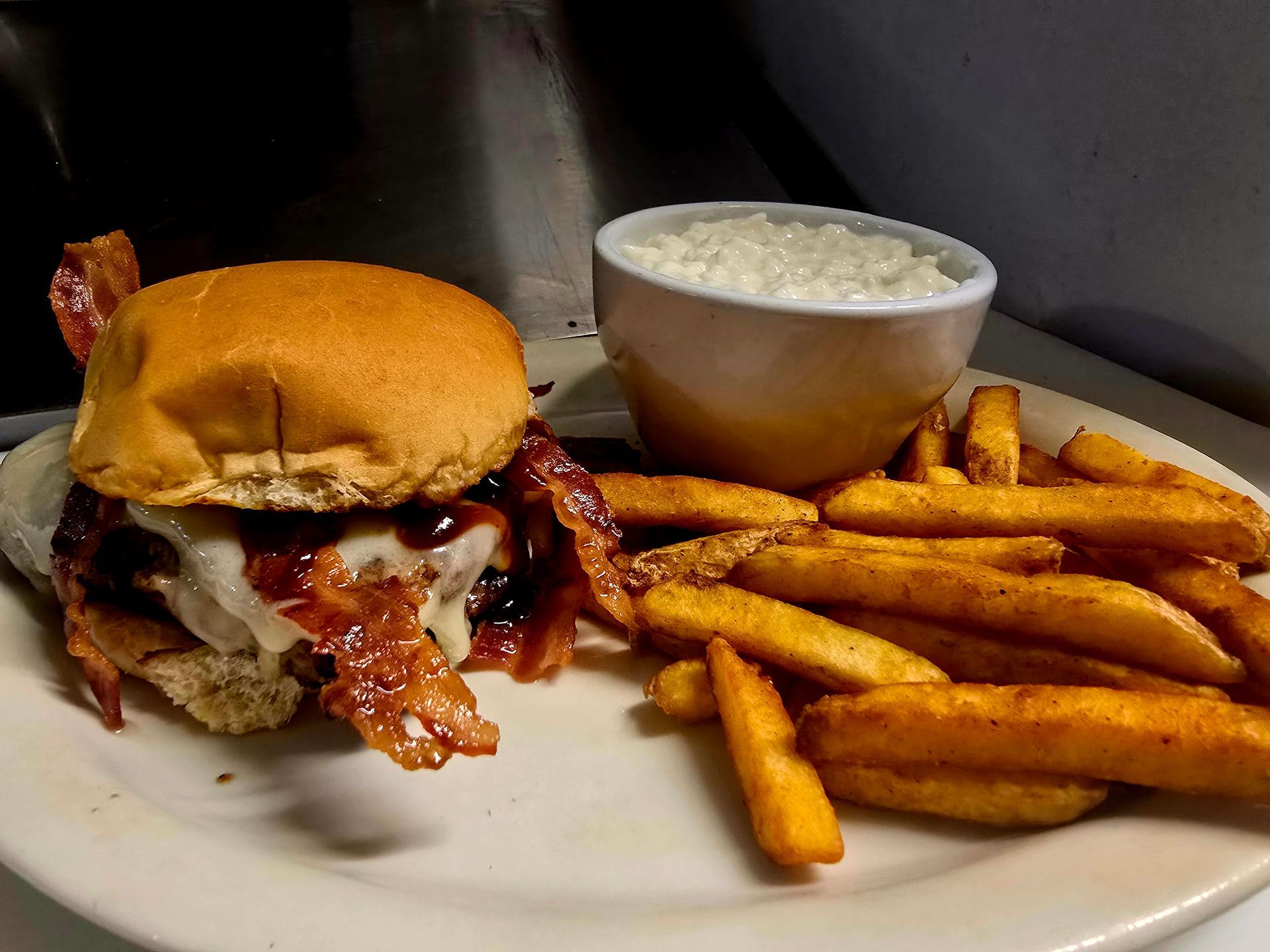 A white plate topped with a hamburger and french fries.