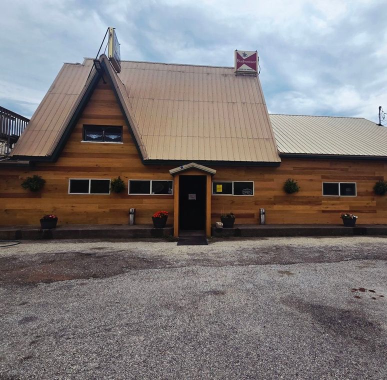 A wooden house with a roof that has a x on it