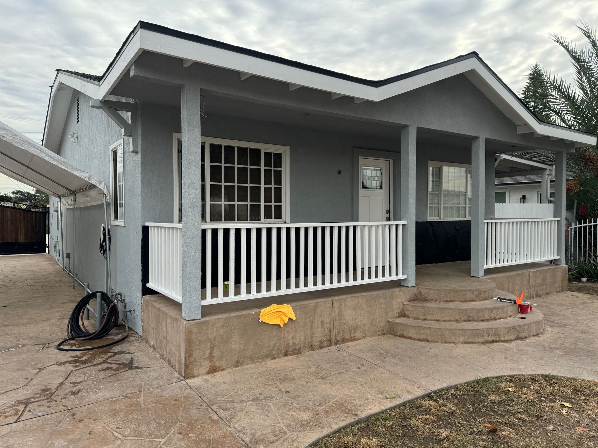 Electrician working on electrical panel, wearing overalls and a cap.