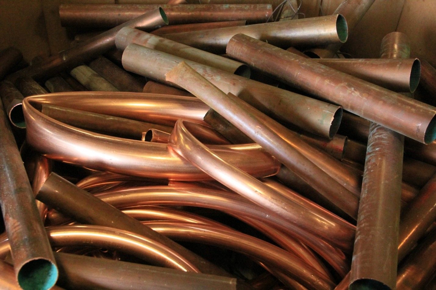 A pile of copper pipes in a cardboard box