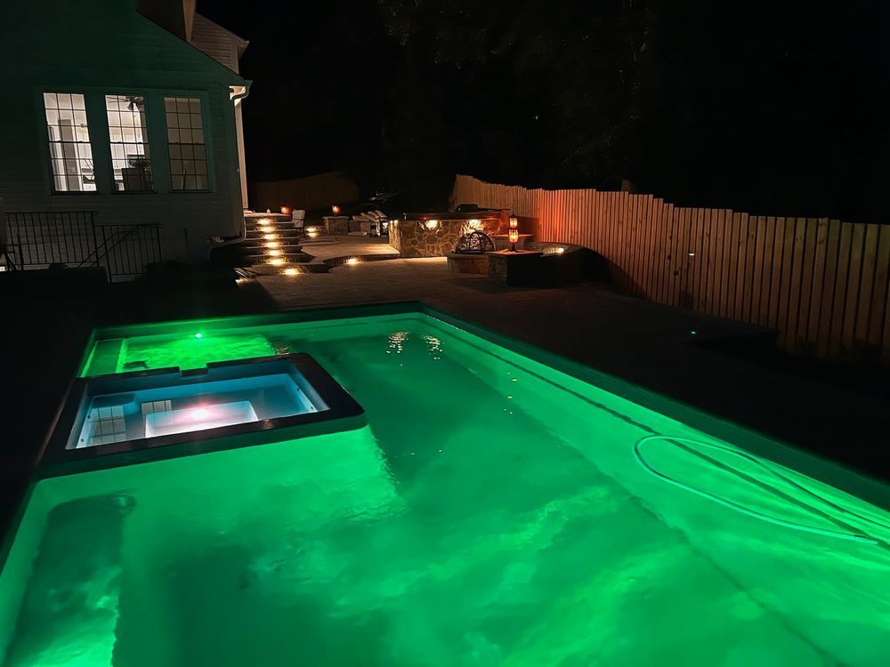 A swimming pool is lit up with green lights at night.
