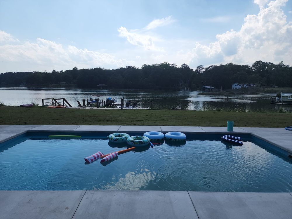 A large swimming pool with a view of a lake.