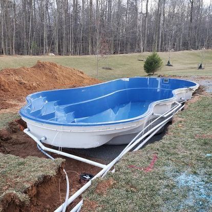 A large swimming pool is being built in a backyard.