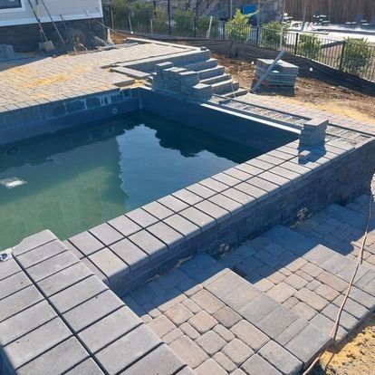 A large swimming pool is being built in a backyard