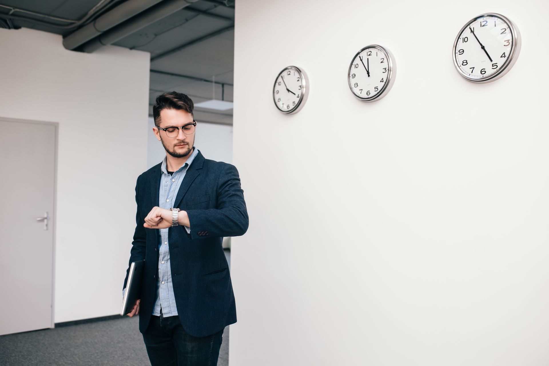 Homem em ambiente corporativo olhando para o relógio