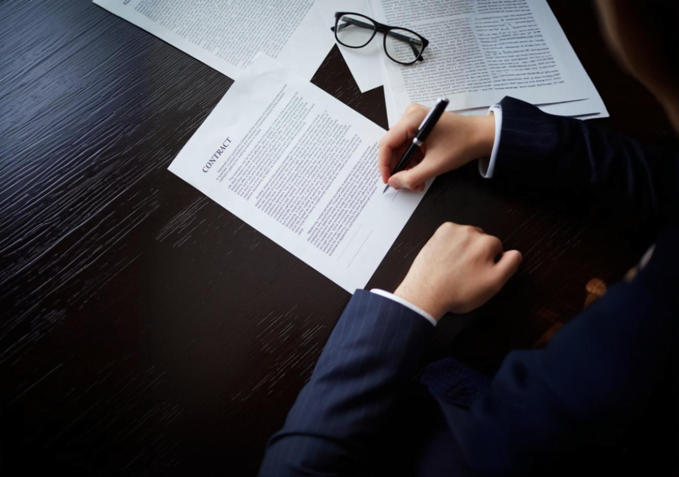 imagem de um homem assinando uma folha de papel