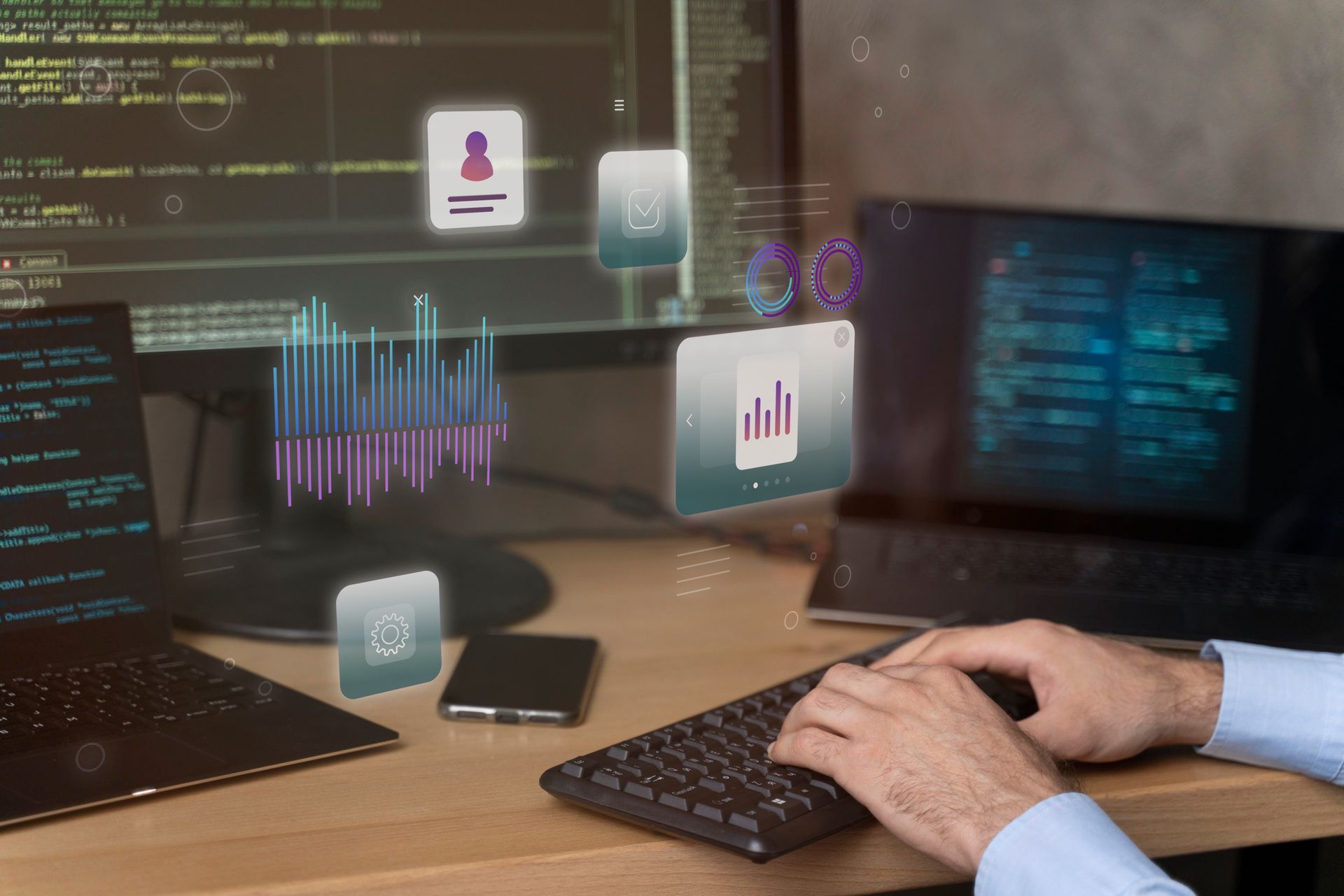 Mãos digitando em um teclado em uma mesa com código e sistemas de dados em várias telas
