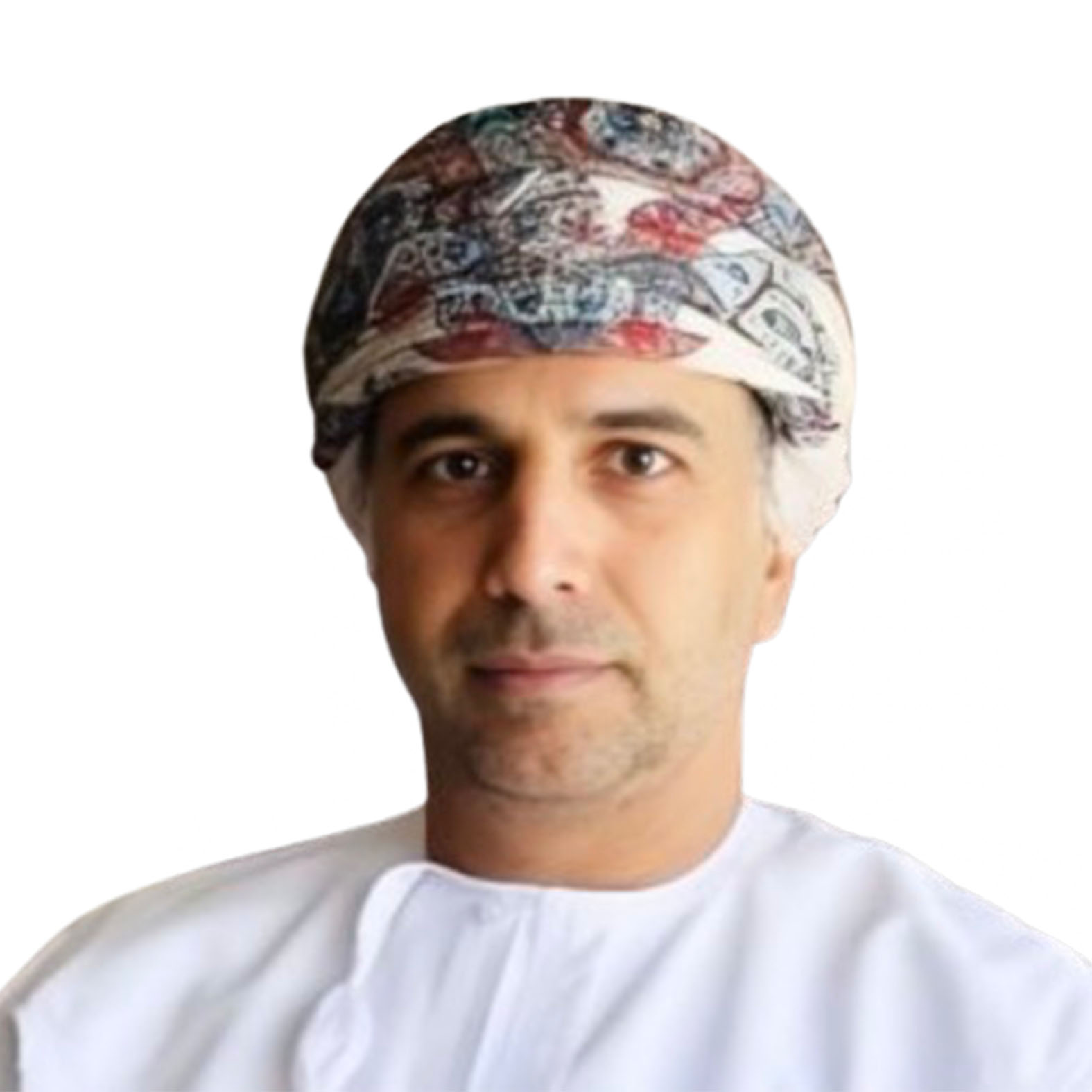 Man wearing a white thobe and a traditional patterned turban, looking at the viewer.