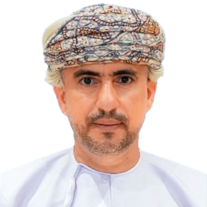 Man wearing a patterned turban and white thobe, looking directly at the viewer.