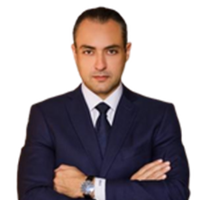 Man in navy suit with arms crossed, looking at the viewer.