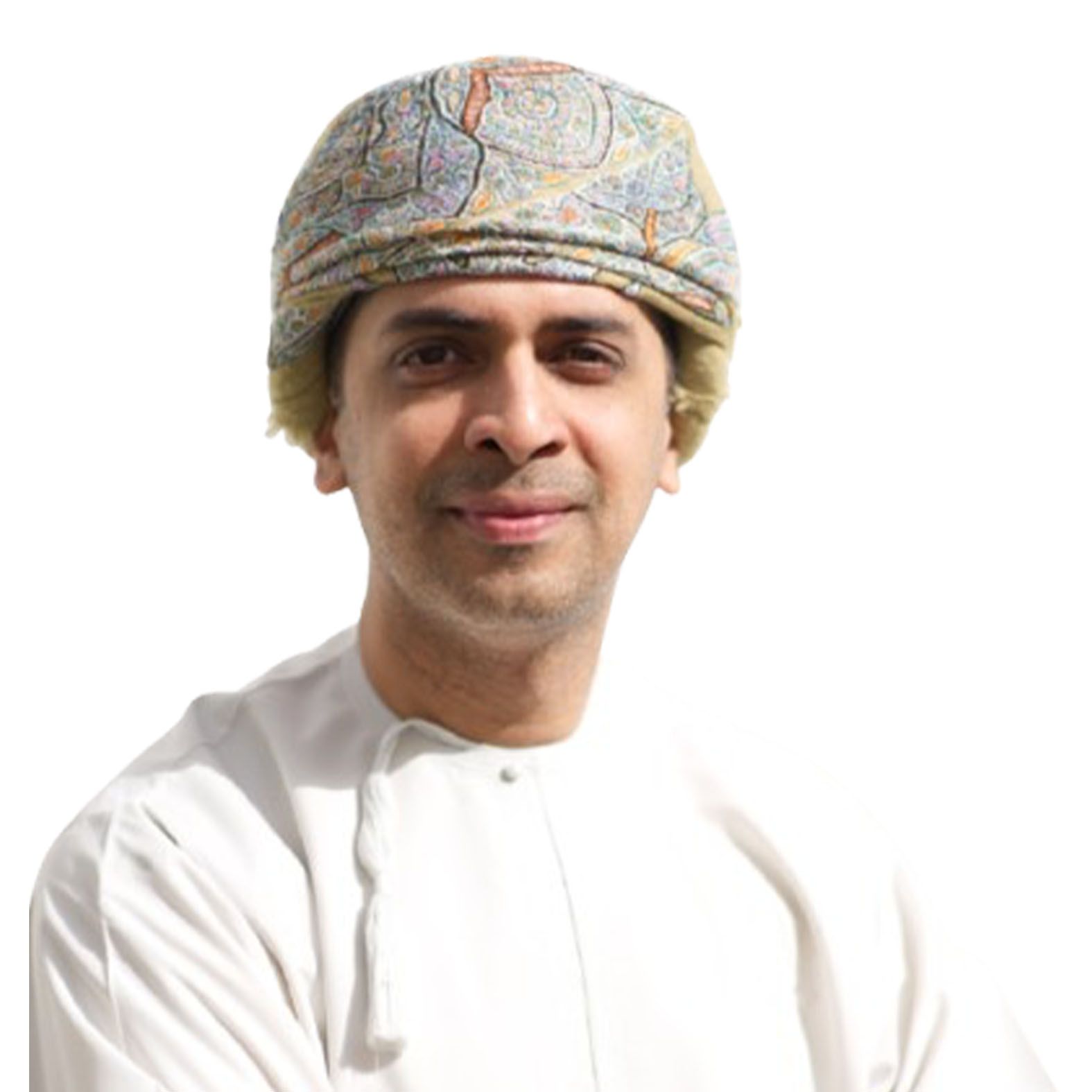 Man wearing a patterned hat and white traditional clothing smiles.