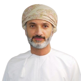 Man in traditional Omani attire; wearing a patterned turban and white dishdasha; neutral expression.