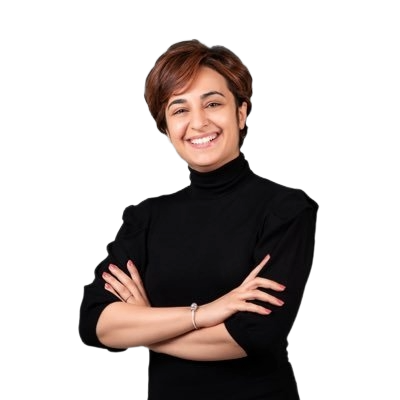 Man in white traditional Omani attire, headscarf, seated at a desk with hands clasped.