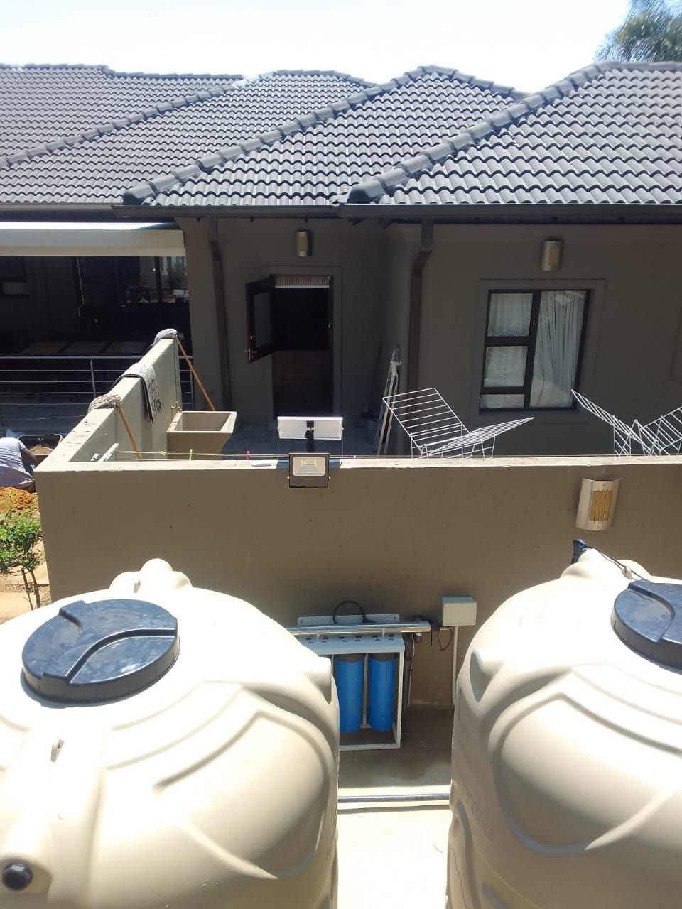 two water tanks are sitting in front of a house