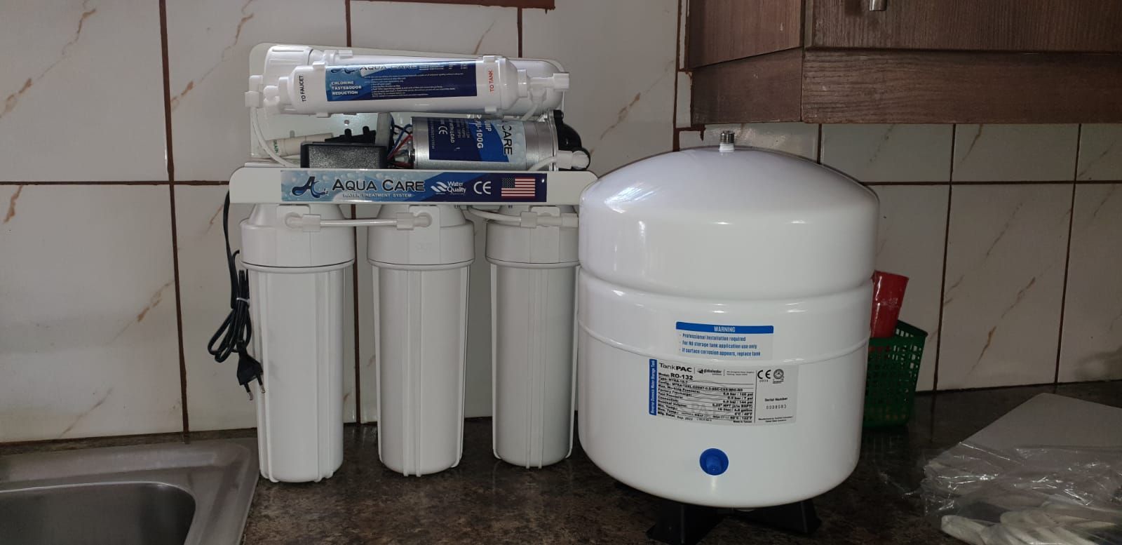 a water filtration system is sitting on a kitchen counter next to a water tank
