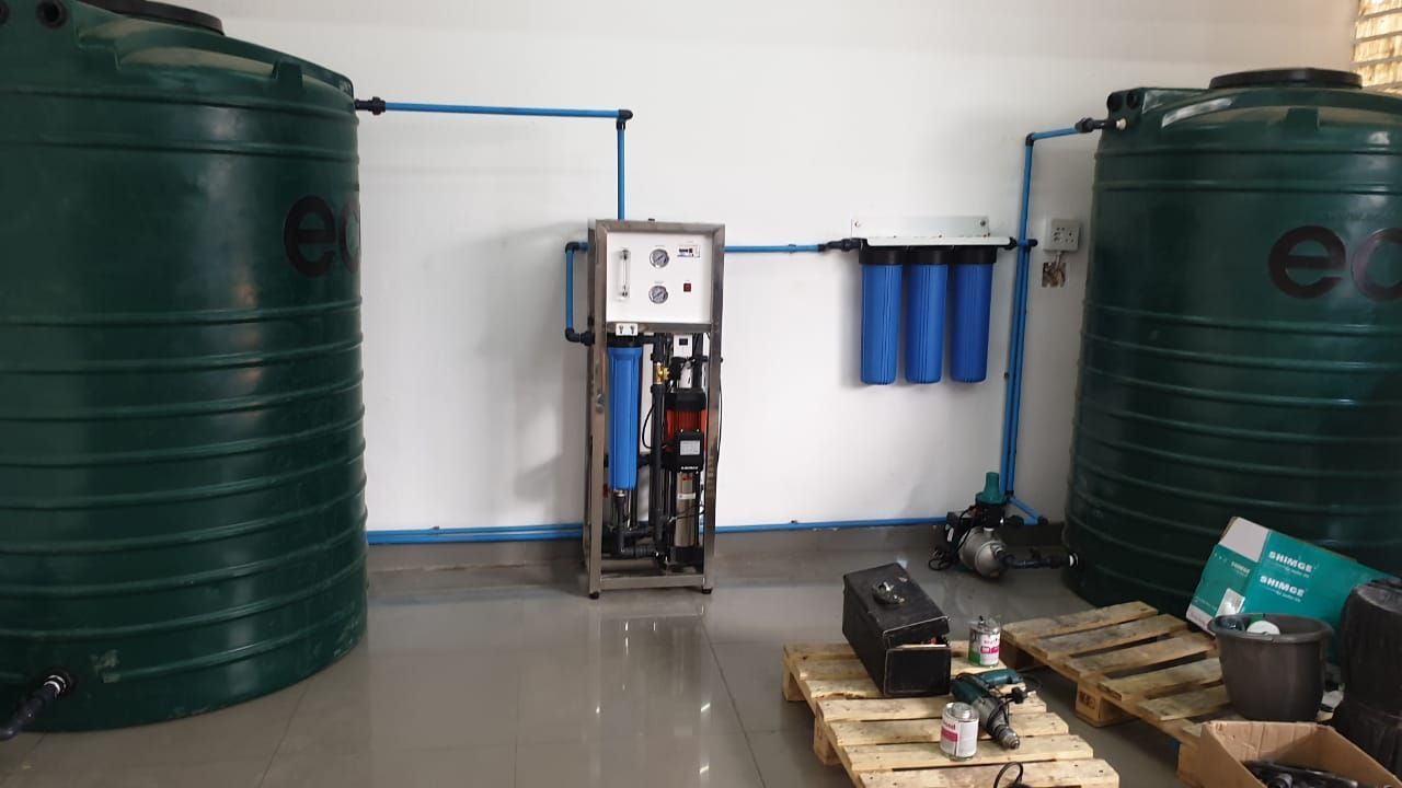 a room with two green jojo tanks and a machine on the floor