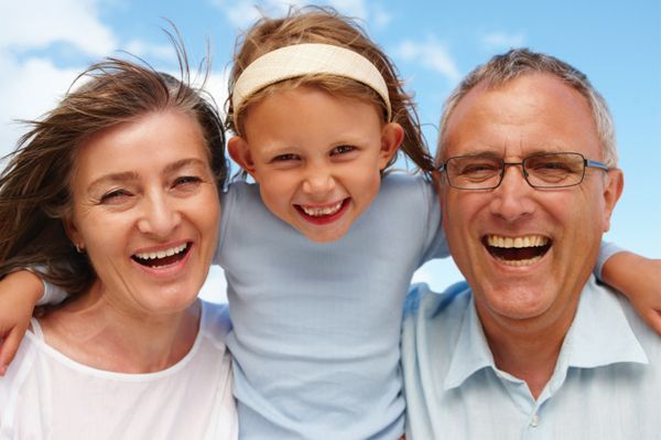 A family is posing for a picture together and smiling.