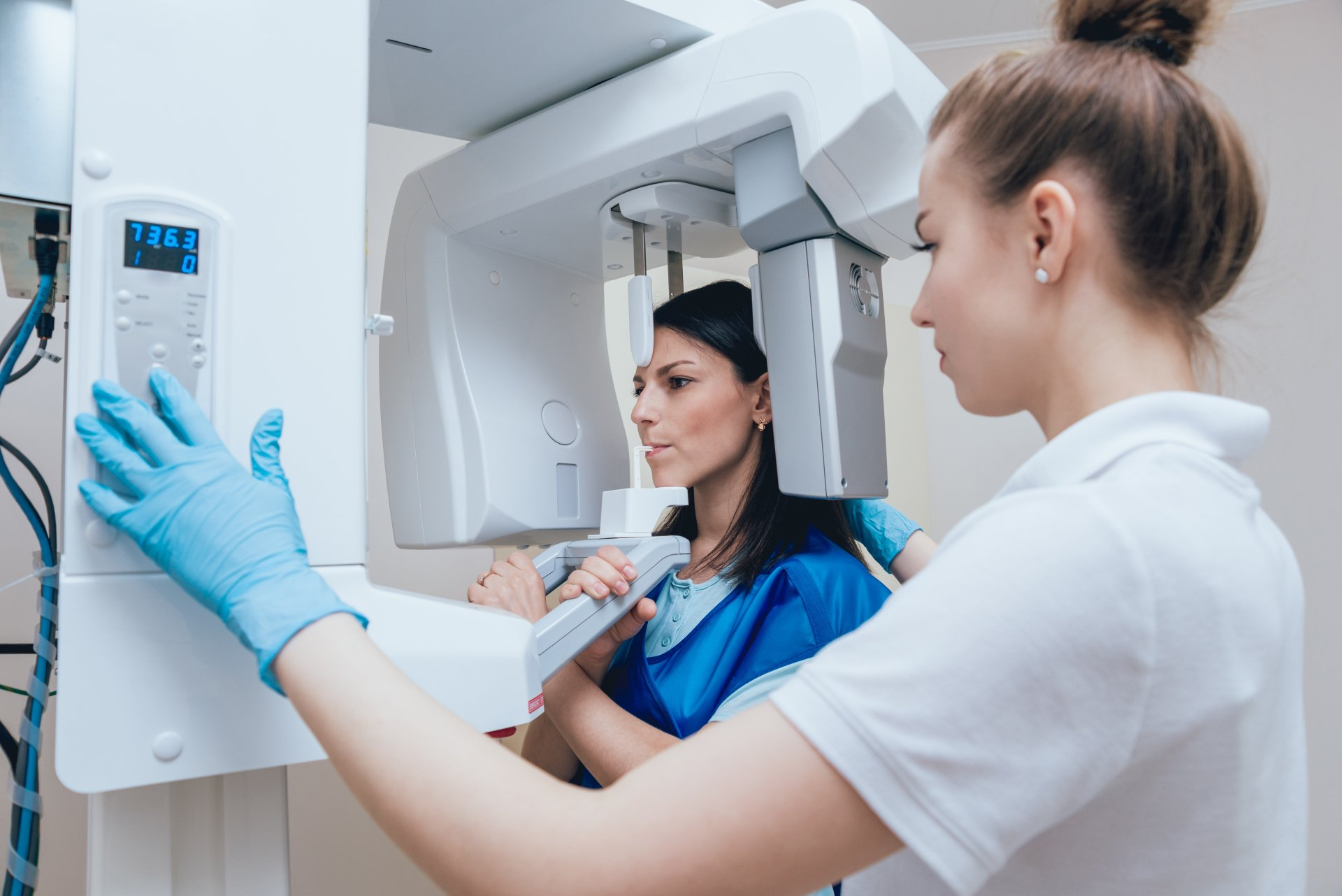 A woman is getting an x-ray of her teeth in a dental office.