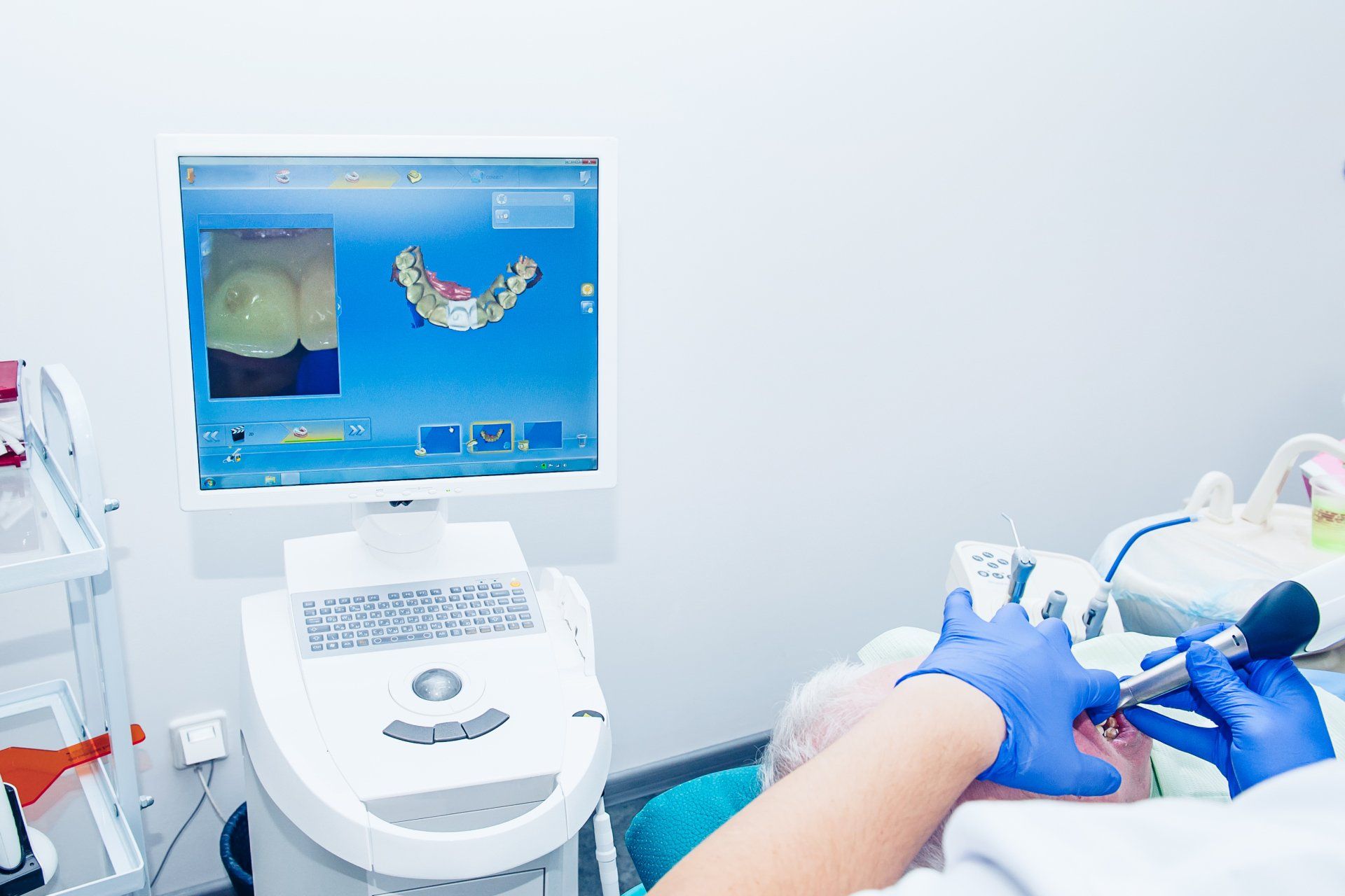 A dentist is working on a patient 's teeth in a dental office.