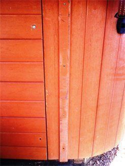 A close up of a wooden door with a screw in it.