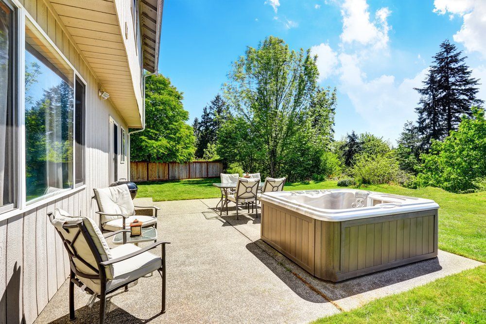There is a hot tub in the backyard of a house.