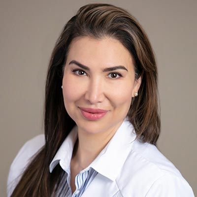 a woman in a white lab coat is smiling for the camera .