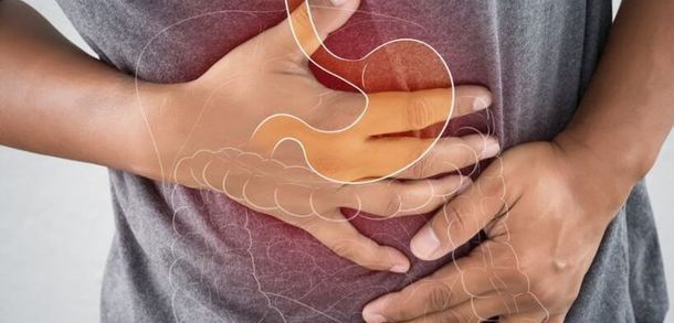 A person is holding their stomach in pain.