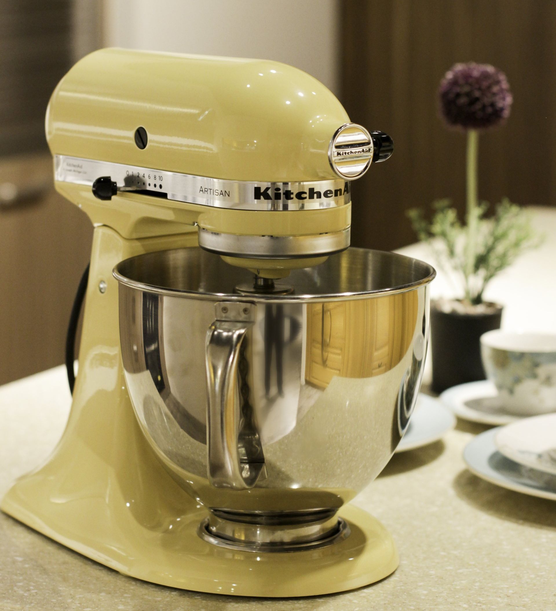 A yellow kitchenaid mixer sits on a counter