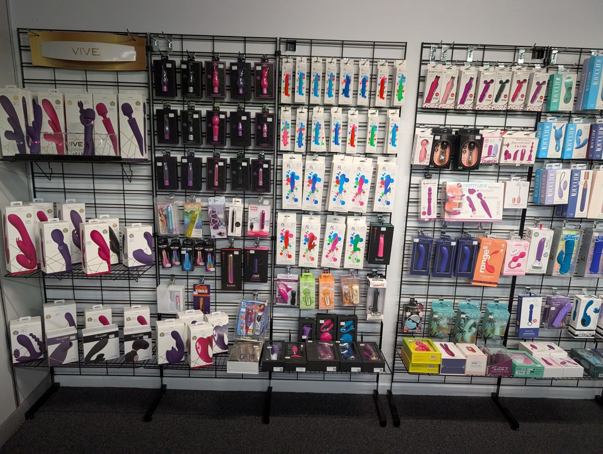 A store display wall featuring an organized collection of various vibrators and personal wellness products in packaging — A Bit Cheeky The Adult Store In Lismore, NSW