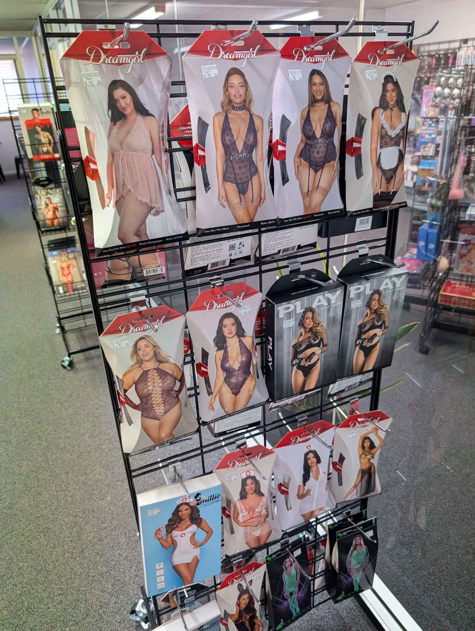 A retail display rack featuring various packages of lingerie and adult costumes in a store setting — A Bit Cheeky The Adult Store In Lismore, NSW