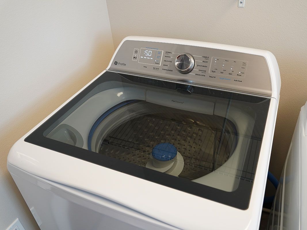Uma máquina de lavar branca está em uma lavanderia