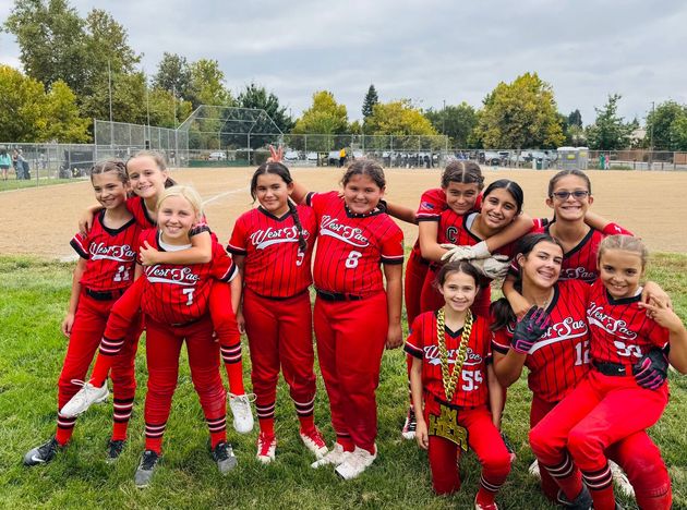 Baseball player sliding into home plate, catcher in front. Blue and gold uniforms, action shot.