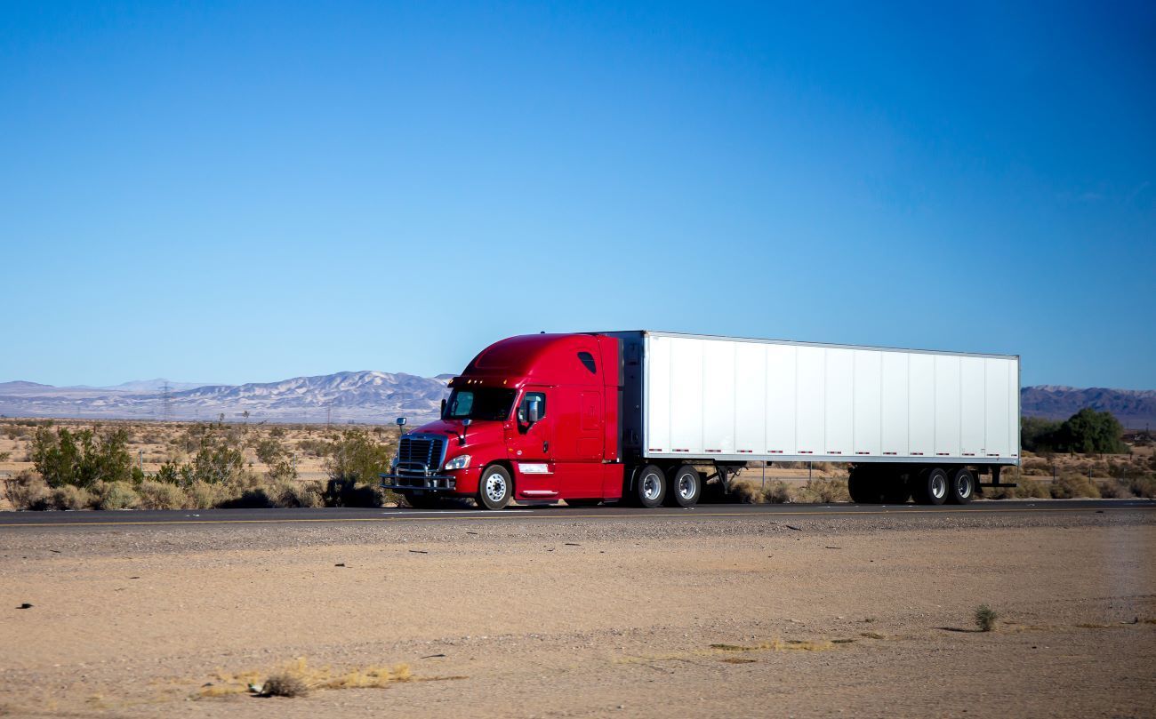 a red semi truck is using the jake brake.